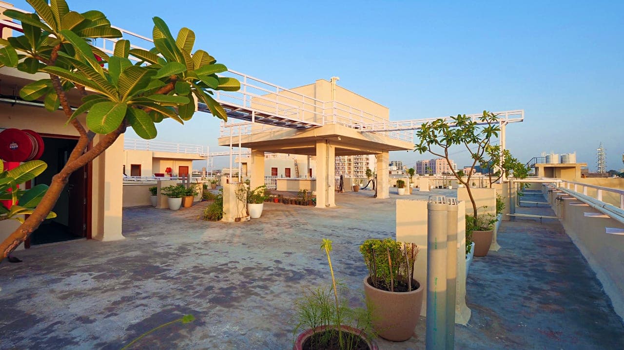Landscaped rooftop terrace at Green Leaf Residency in golden light